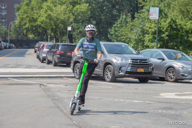 A person making a turn on a Lime e-scooter. 